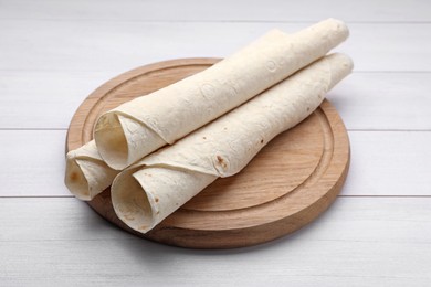 Photo of Delicious rolled Armenian lavash on white wooden table