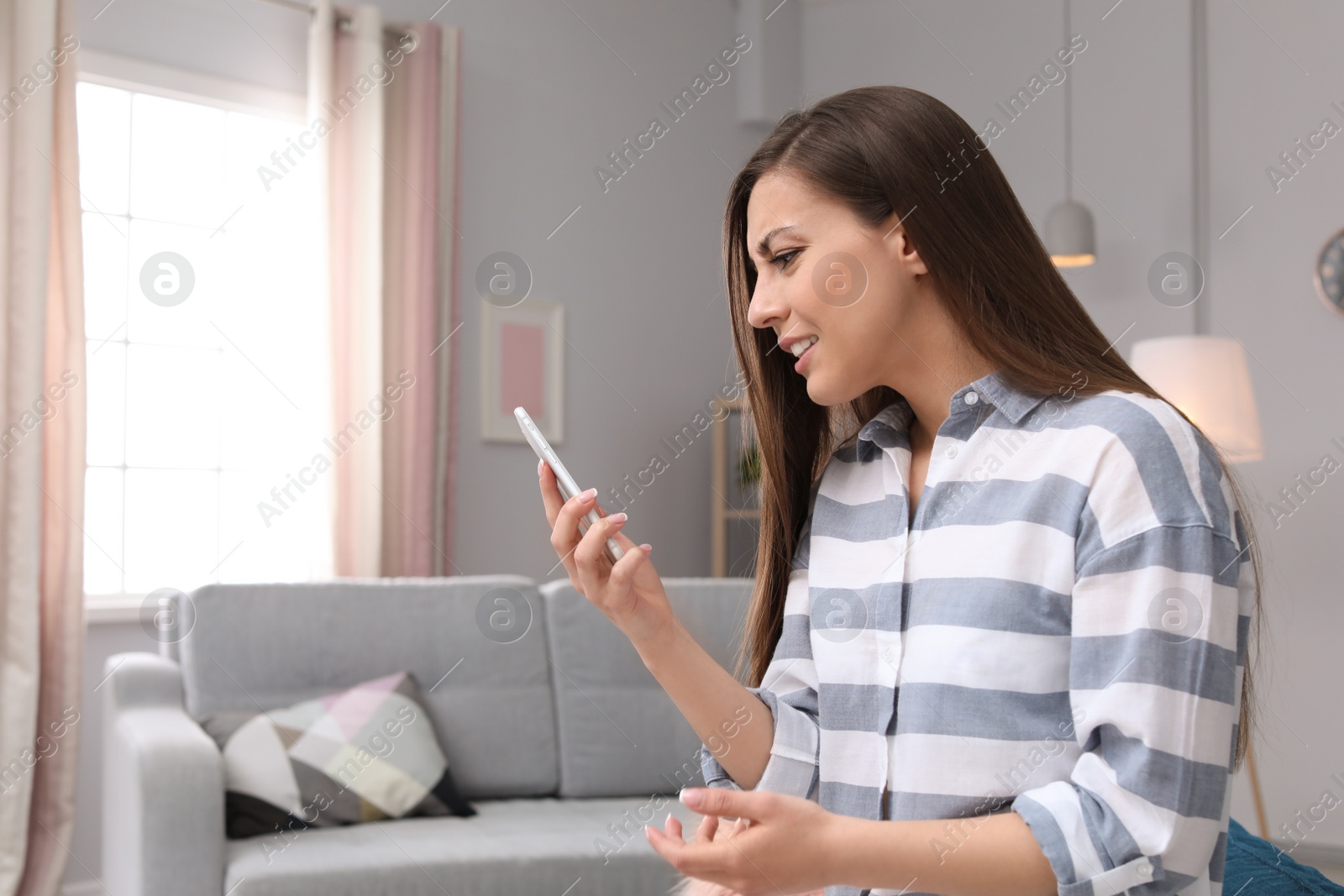 Photo of Woman arguing on mobile phone at home