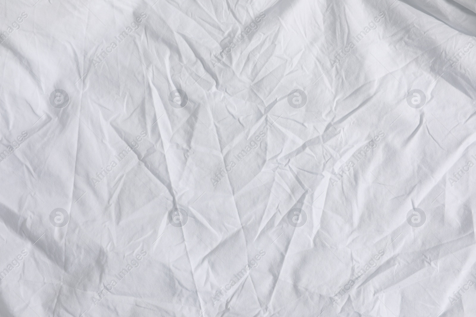 Photo of Crumpled white fabric as background, top view