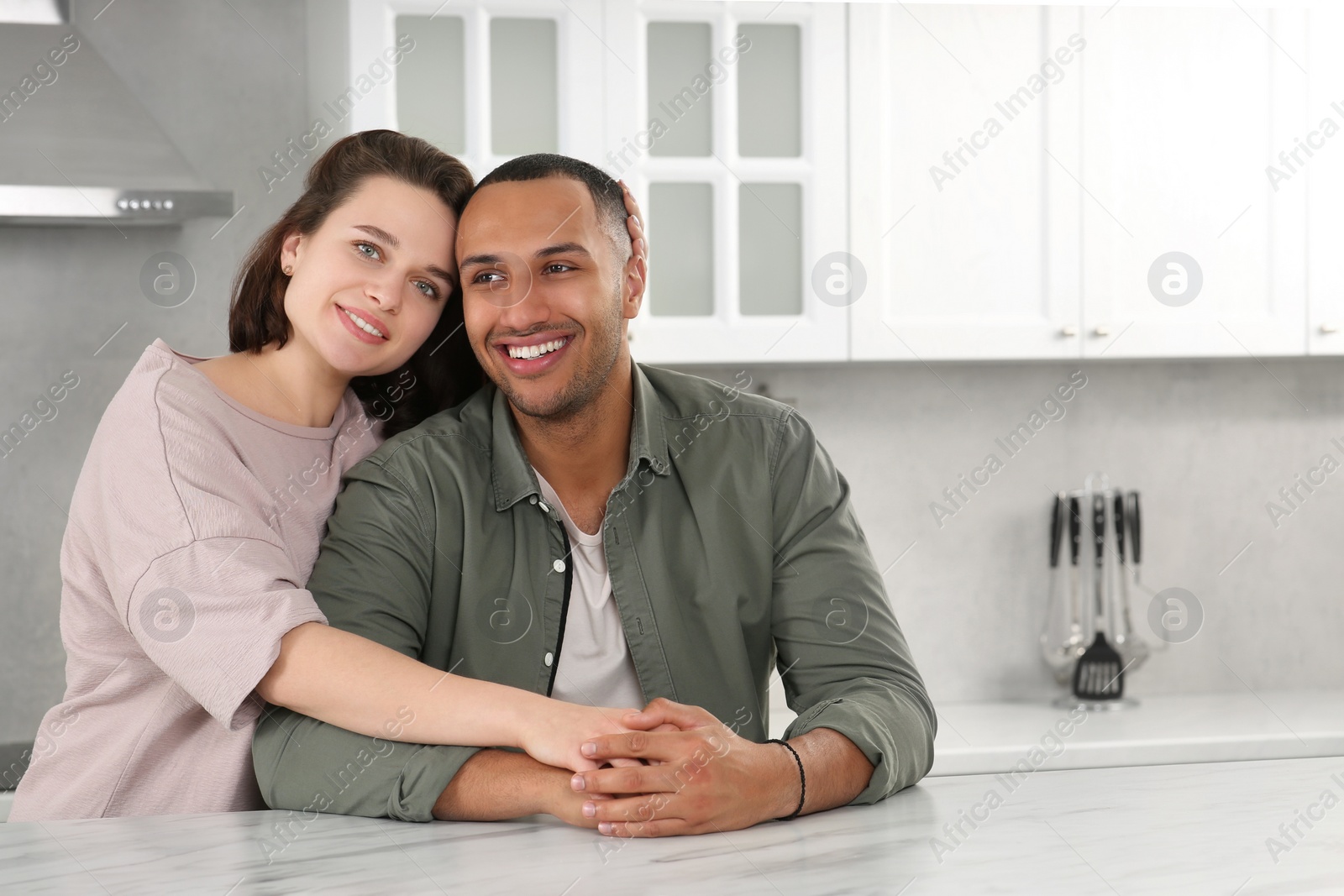 Photo of Dating agency. Woman embracing her boyfriend in kitchen, space for text