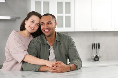 Photo of Dating agency. Woman embracing her boyfriend in kitchen, space for text