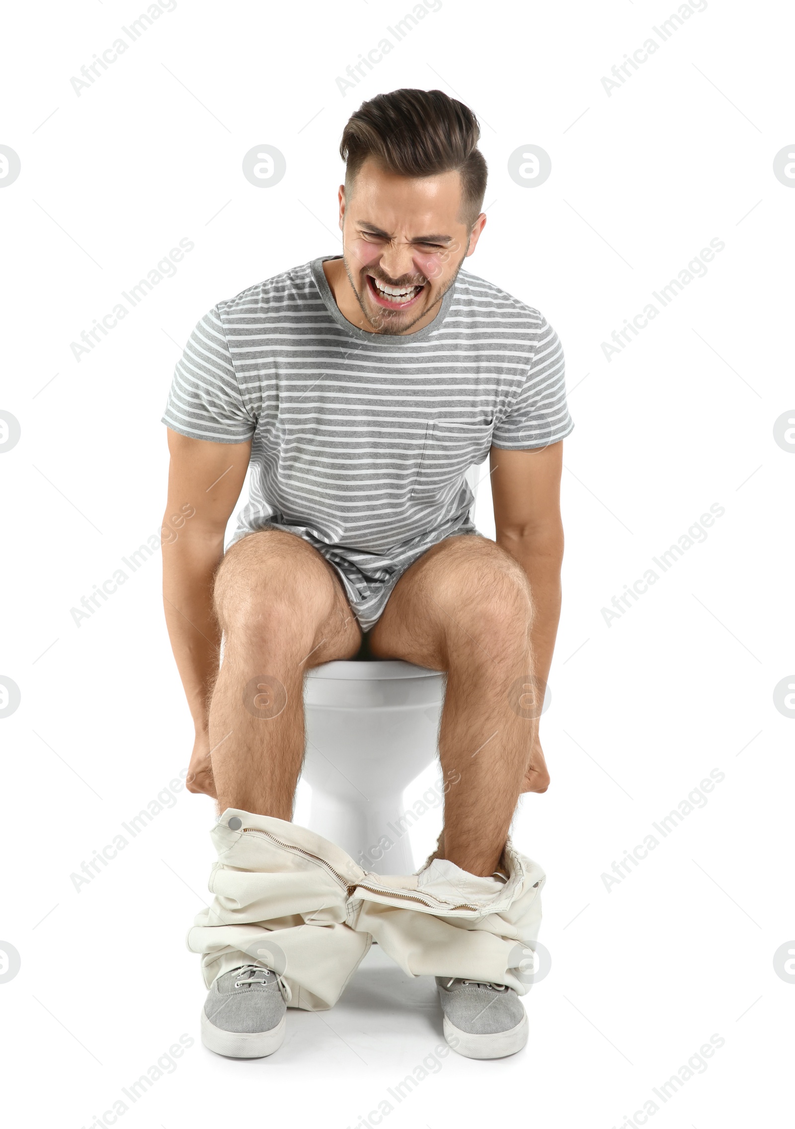 Photo of Young man suffering from diarrhea on toilet bowl. Isolated on white