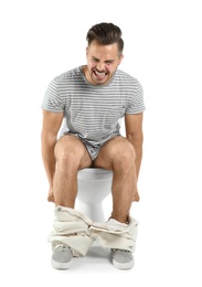 Photo of Young man suffering from diarrhea on toilet bowl. Isolated on white