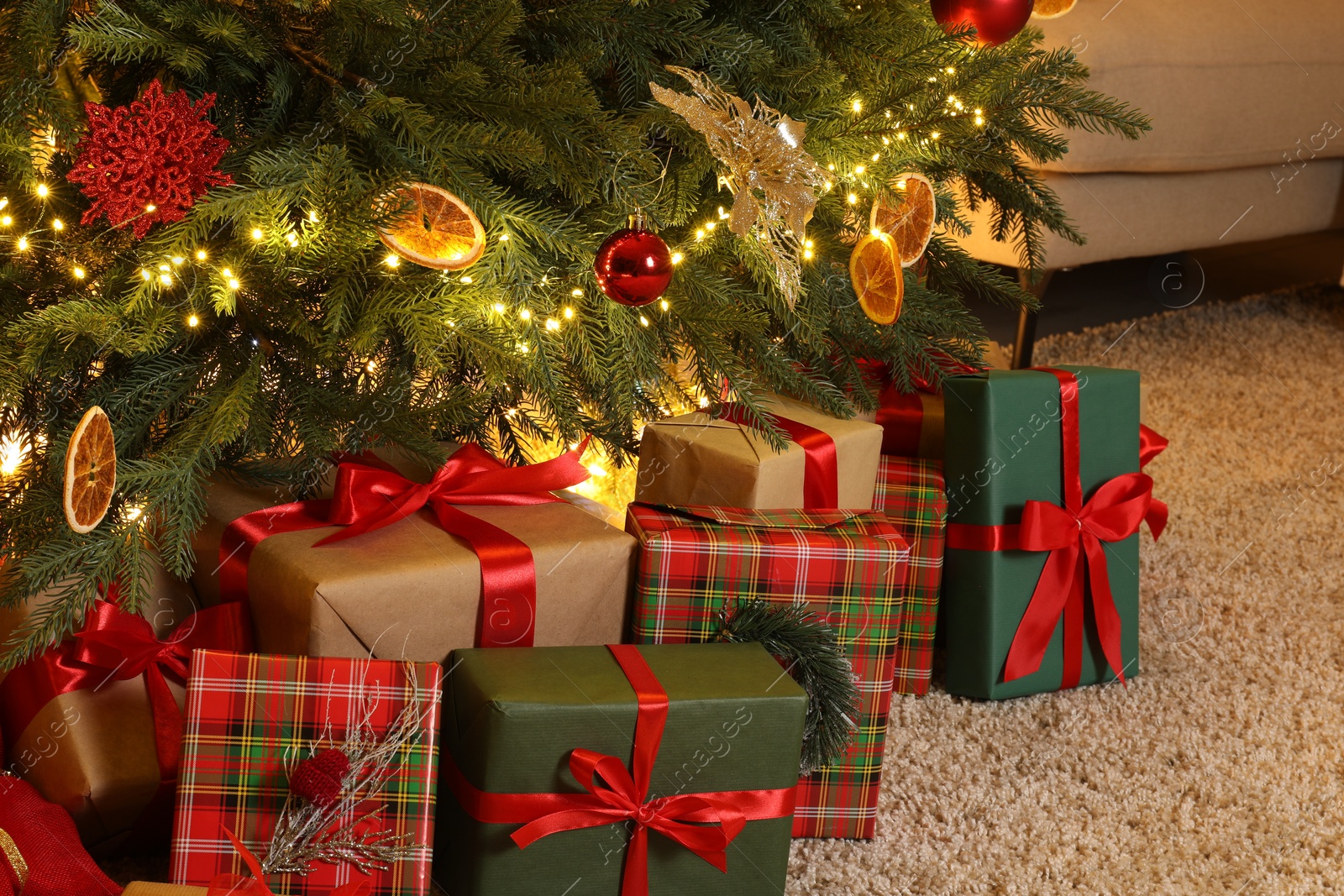 Photo of Many gift boxes under Christmas tree in room
