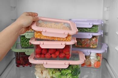 Photo of Woman taking box with corn kernels from refrigerator, closeup