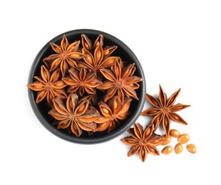 Photo of Bowl and dry anise stars on white background, top view