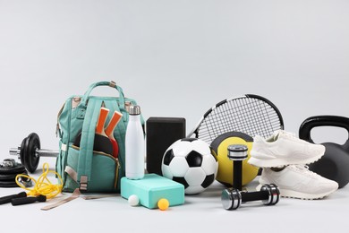 Photo of Many different sports equipment on light grey background