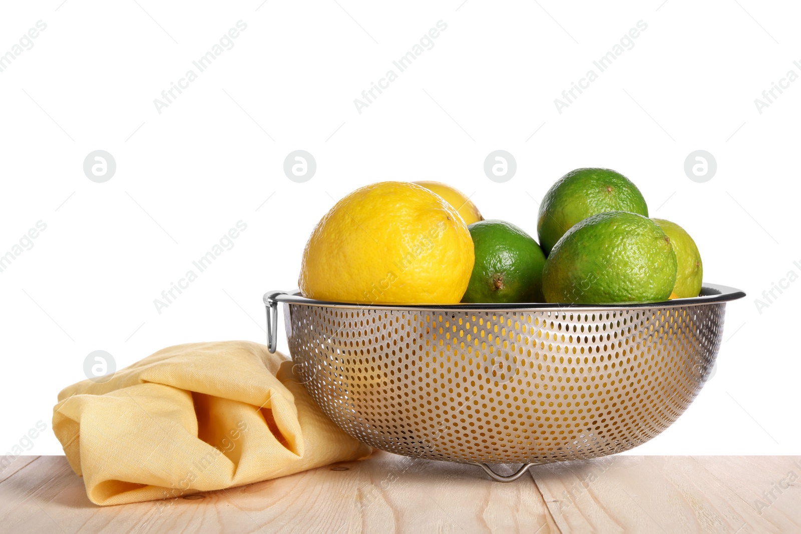 Photo of Fresh fruits in colander and napkin on wooden table against white background