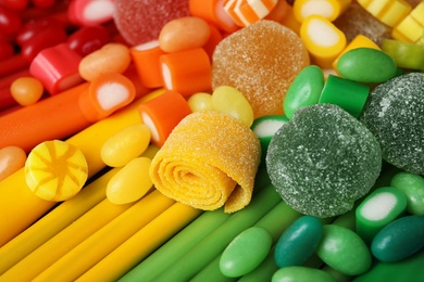 Photo of Different delicious colorful candies as background, closeup
