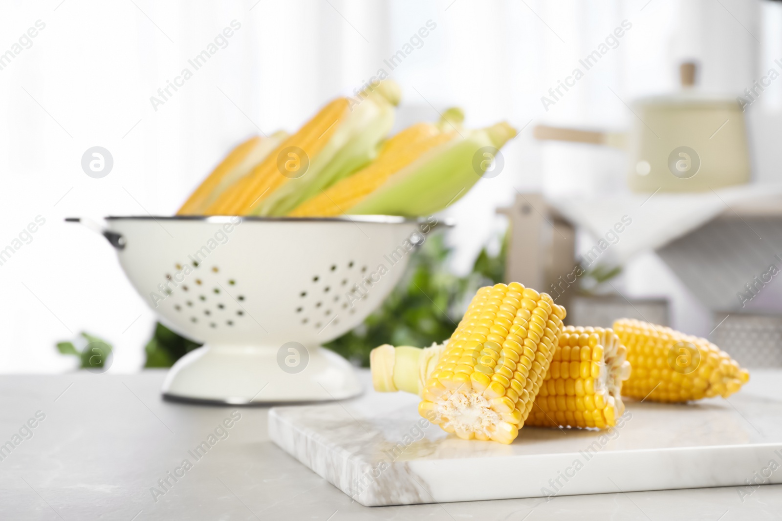 Photo of Tasty sweet corn cob on marble board