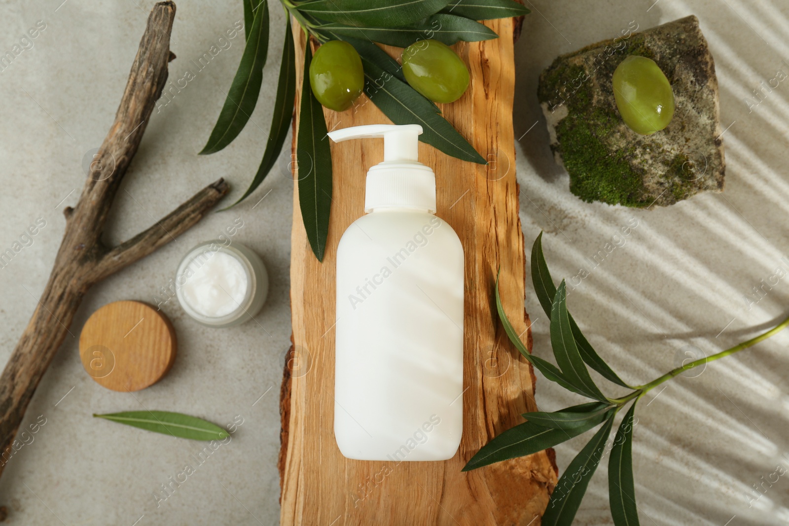 Photo of Cosmetic products with olive essential oil on light grey table, flat lay