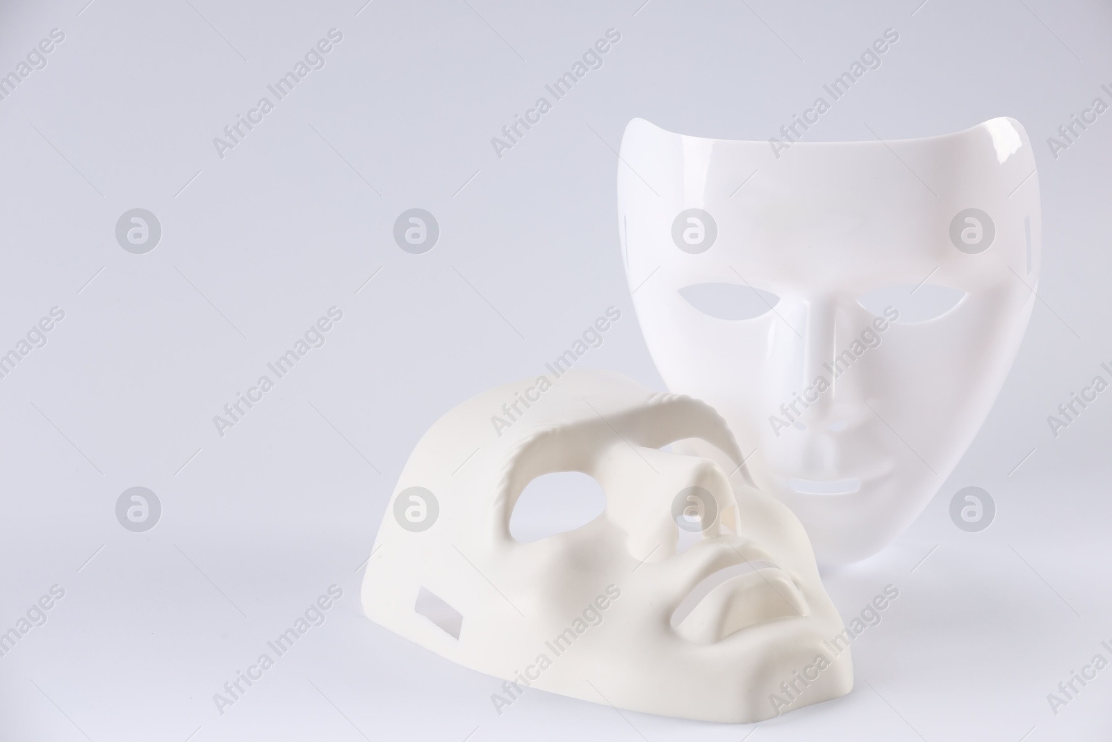 Photo of Plastic face masks on white background, space for text. Theatrical performance