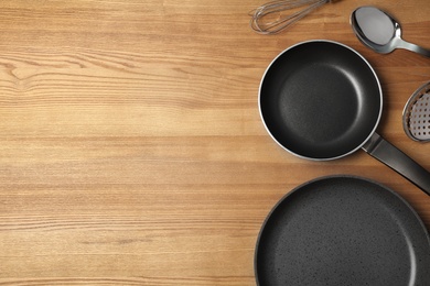 Photo of Flat lay composition with clean cookware and space for text on wooden background