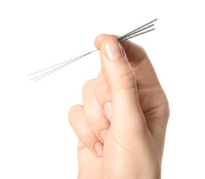 Woman holding needles for acupuncture on white background, closeup