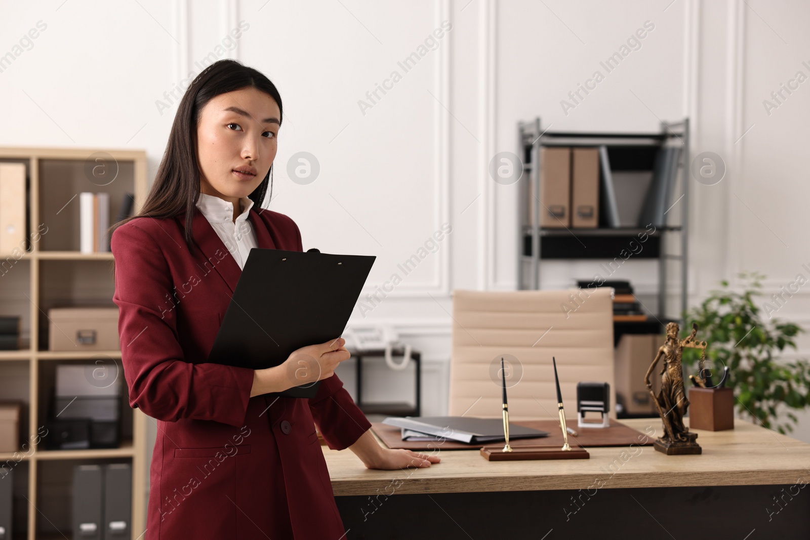 Photo of Portrait of notary with clipboard in office. Space for text