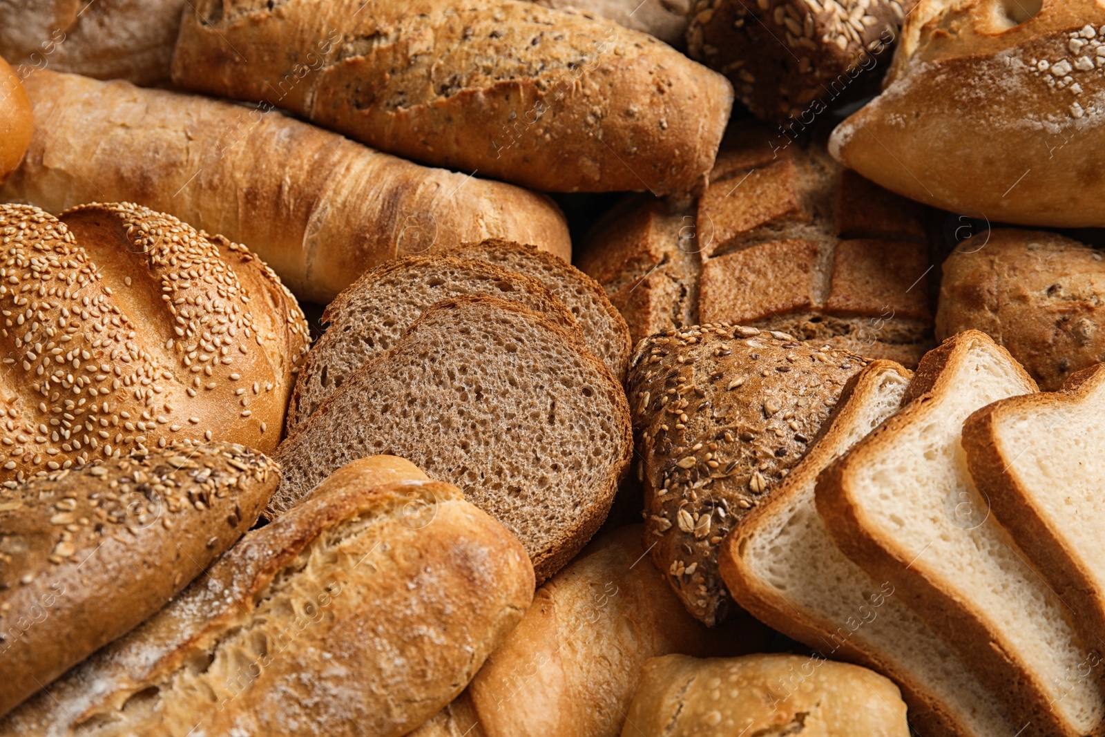 Photo of Different kinds of fresh bread as background, closeup