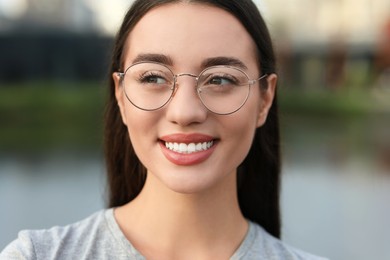 Portrait of beautiful woman in glasses on blurred background. Attractive lady smiling and posing for camera