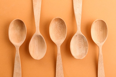 Flat lay composition with clean wooden spoons on color background