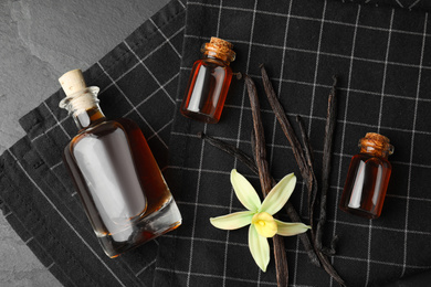 Flat lay composition with vanilla extract on black table