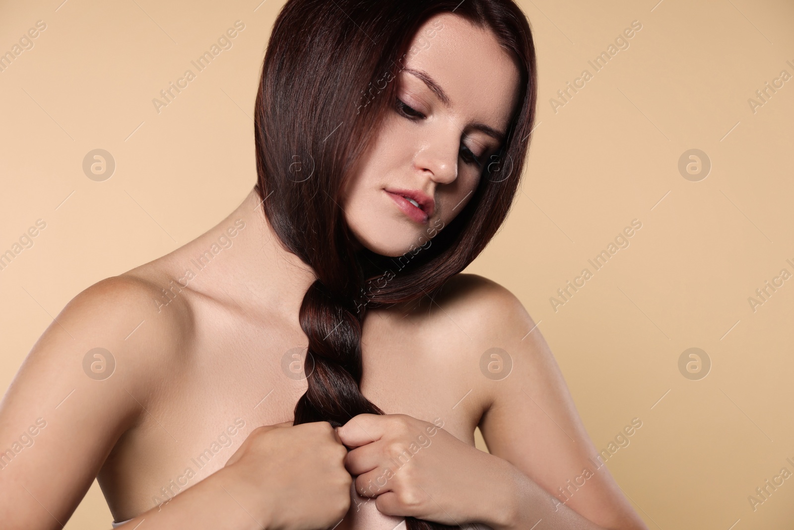 Photo of Portrait of beautiful young woman with healthy strong hair on beige background