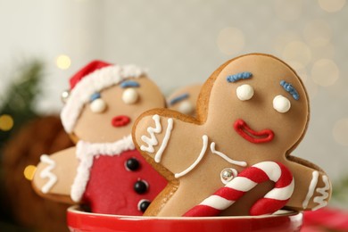 Delicious homemade Christmas cookies in bowl against blurred festive lights, closeup