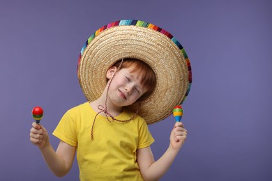 Photo of Cute boy in Mexican sombrero hat dancing with maracas on white background, space for text