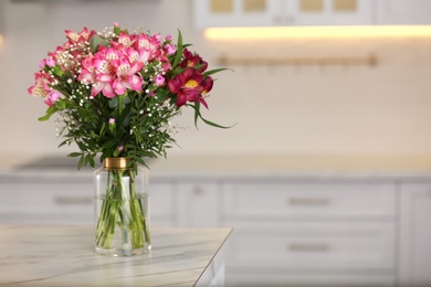 Photo of Vase with beautiful alstroemeria flowers on table in kitchen, space for text. Interior design