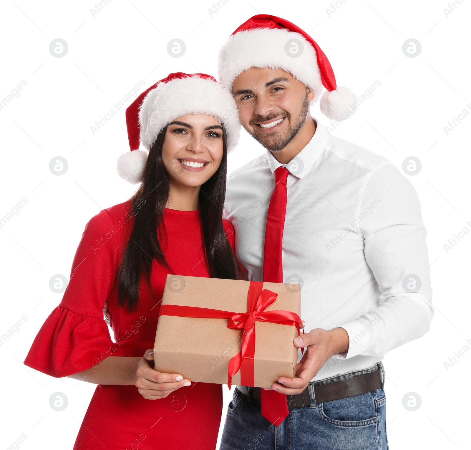 Photo of Lovely young couple in Santa hats with gift box on white background. Christmas celebration