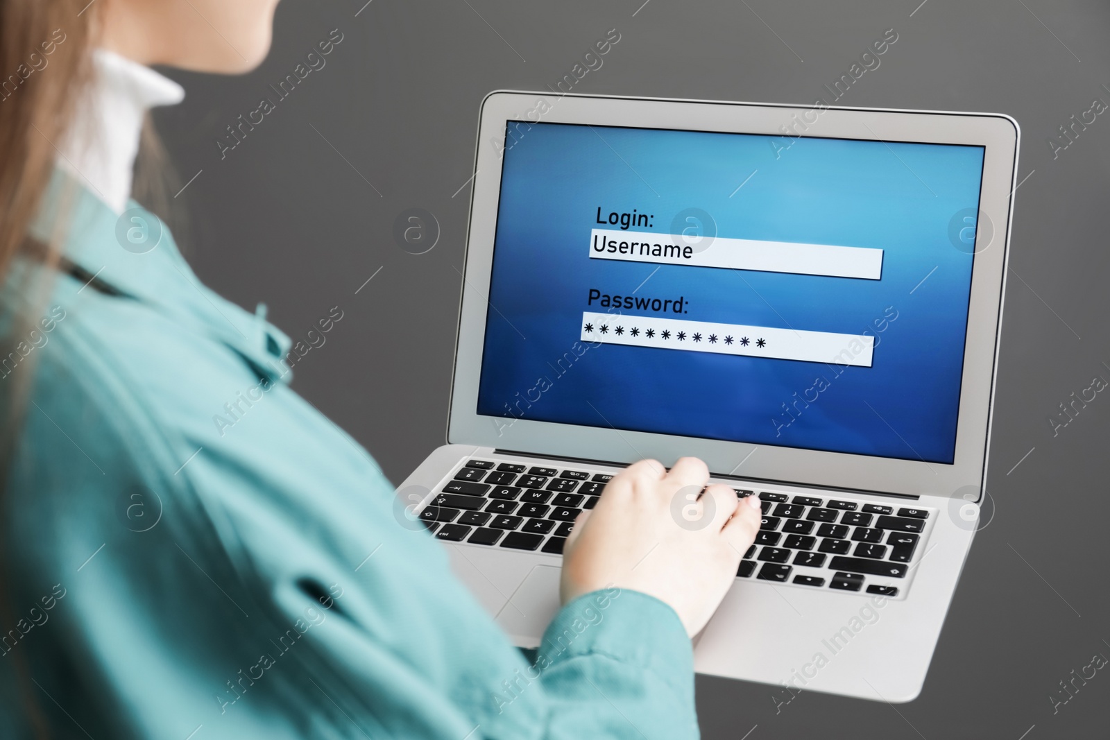 Photo of Woman unlocking laptop with blocked screen on grey background, closeup