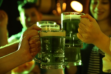 People with beer celebrating St Patrick's day in pub, closeup