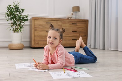 Photo of Cute little girl coloring on warm floor at home. Heating system