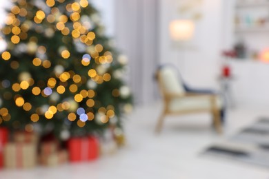 Blurred view of beautiful Christmas tree with festive lights in living room