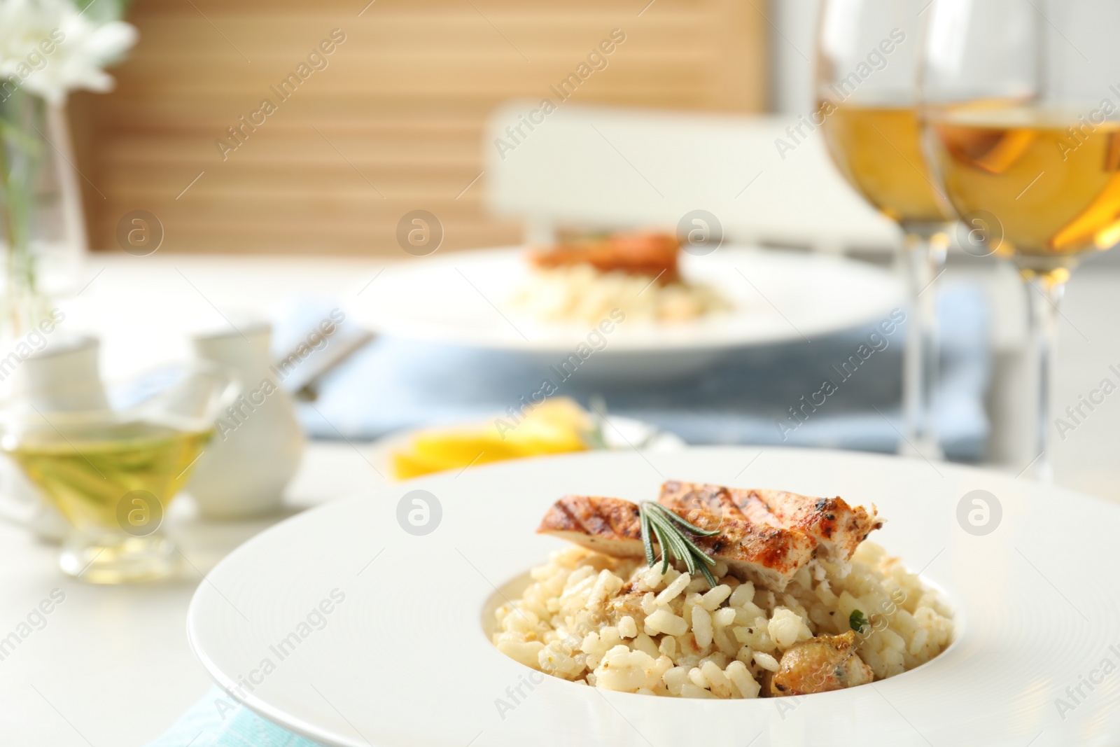 Photo of Delicious chicken risotto with rosemary served on table