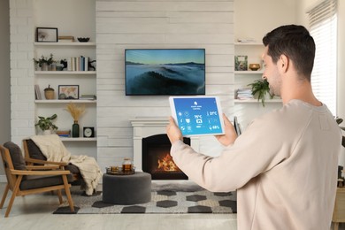 Man using smart home control system via application on tablet indoors