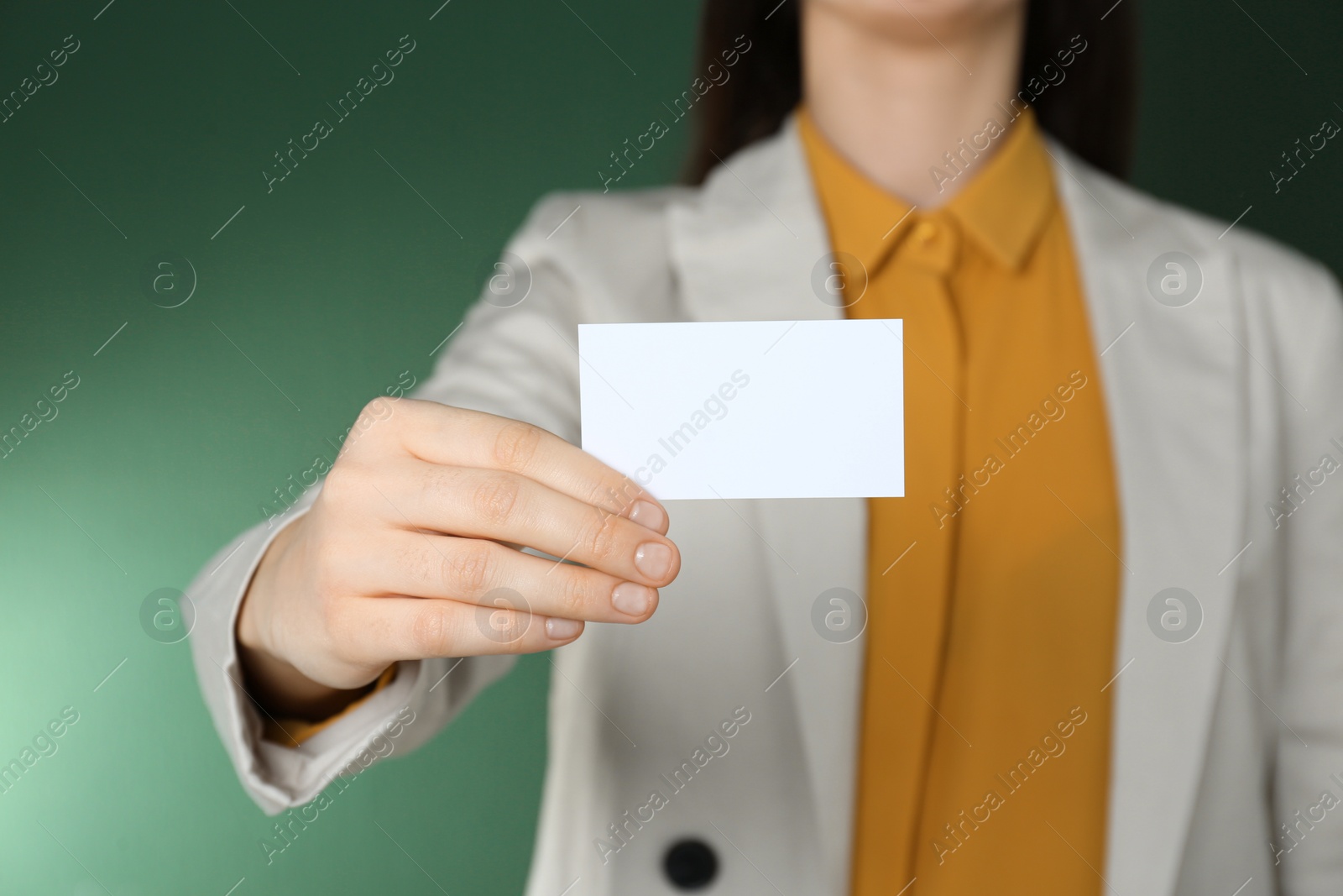 Photo of Woman holding white business card on green background, closeup