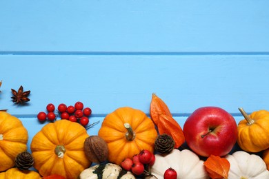 Photo of Thanksgiving day. Flat lay composition with pumpkins on light blue wooden table, space for text