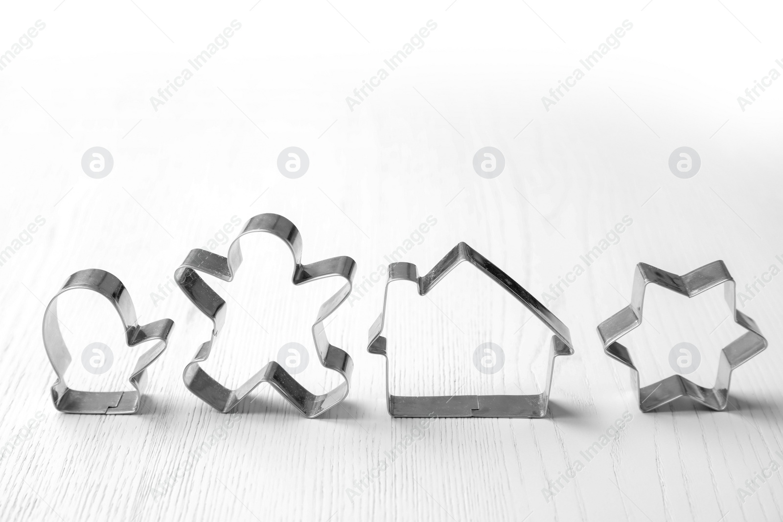 Photo of Cutters for Christmas cookies on wooden table