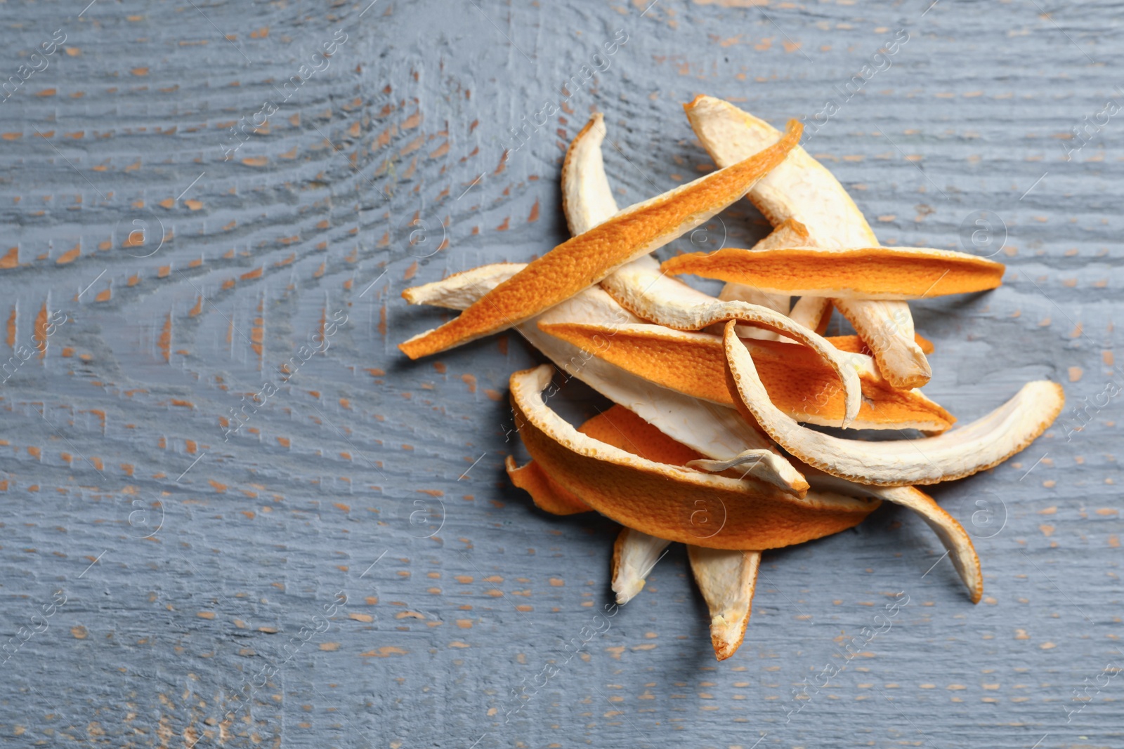 Photo of Dry orange peels on wooden table, flat lay. Space for text