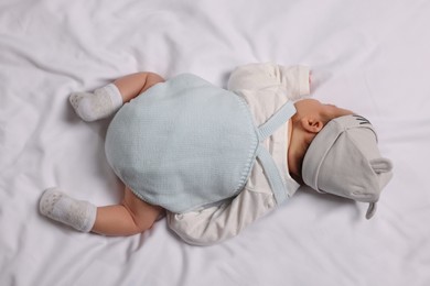 Photo of Newborn baby lying on white blanket, top view