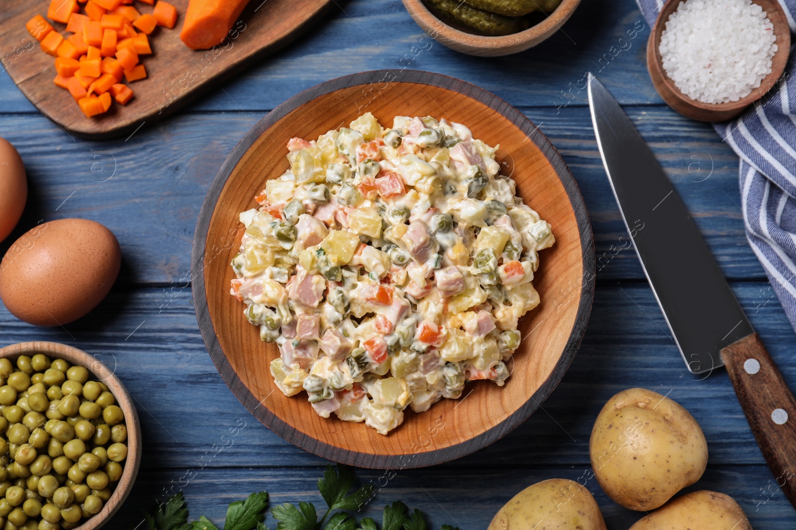 Photo of Delicious salad Olivier on blue wooden table, flat lay