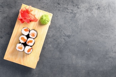 Photo of Tasty sushi rolls served on grey table, top view with space for text. Food delivery