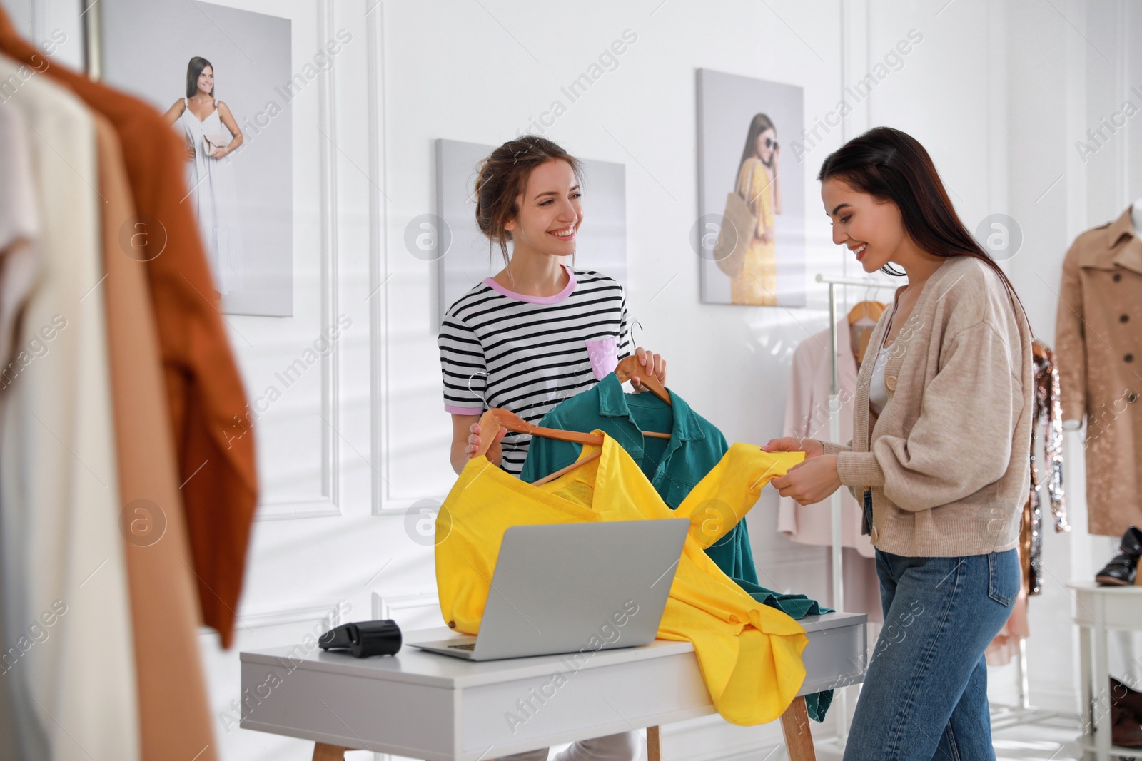 Photo of Young woman buying clothes in modern boutique