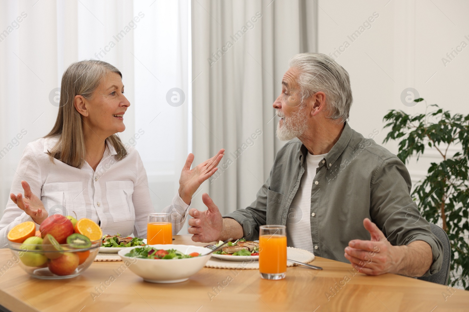 Photo of Happy senior couple having dinner at home