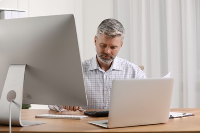 Photo of Professional accountant working at wooden desk in office