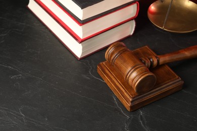 Photo of Wooden gavel and books on dark textured table. Space for text