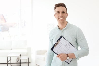 Photo of Male real estate agent with clipboard indoors