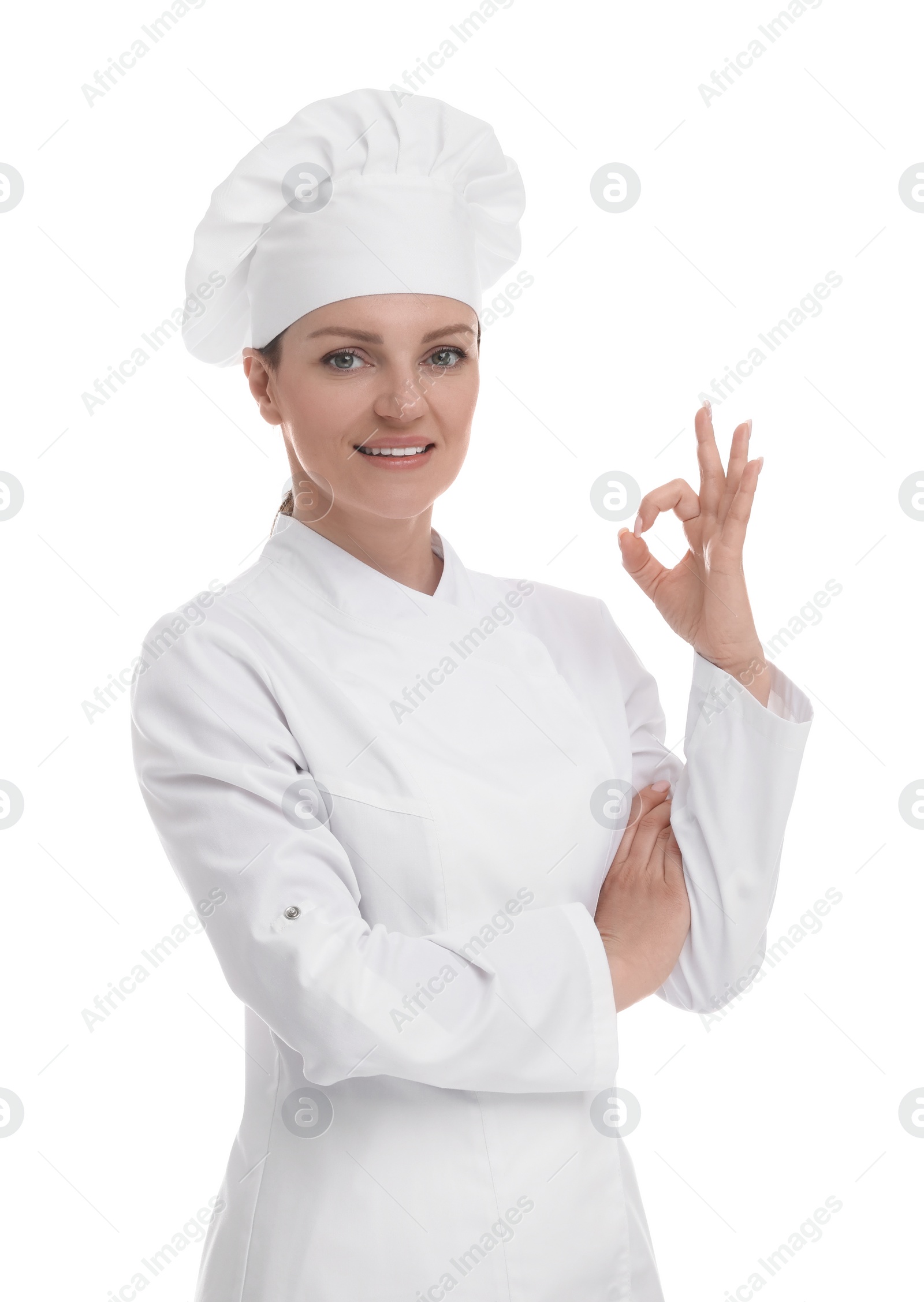 Photo of Happy woman chef in uniform showing OK gesture on white background