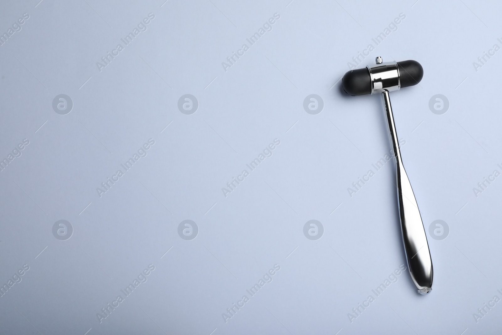 Photo of Reflex hammer on grey background, top view with space for text. Nervous system diagnostic