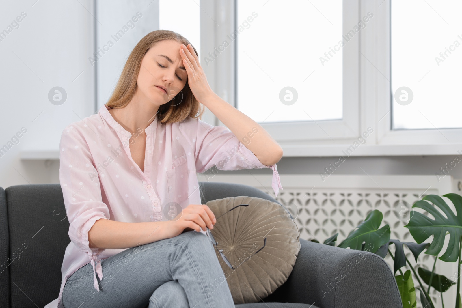 Photo of Overwhelmed young woman suffering from headache at home