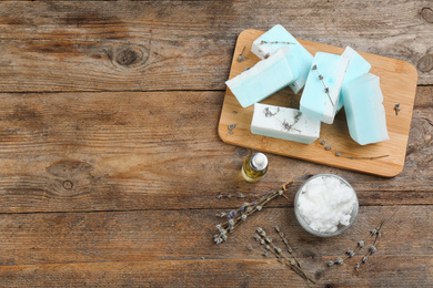 Photo of Flat lay composition with natural handmade soap and ingredients on wooden table, space for text